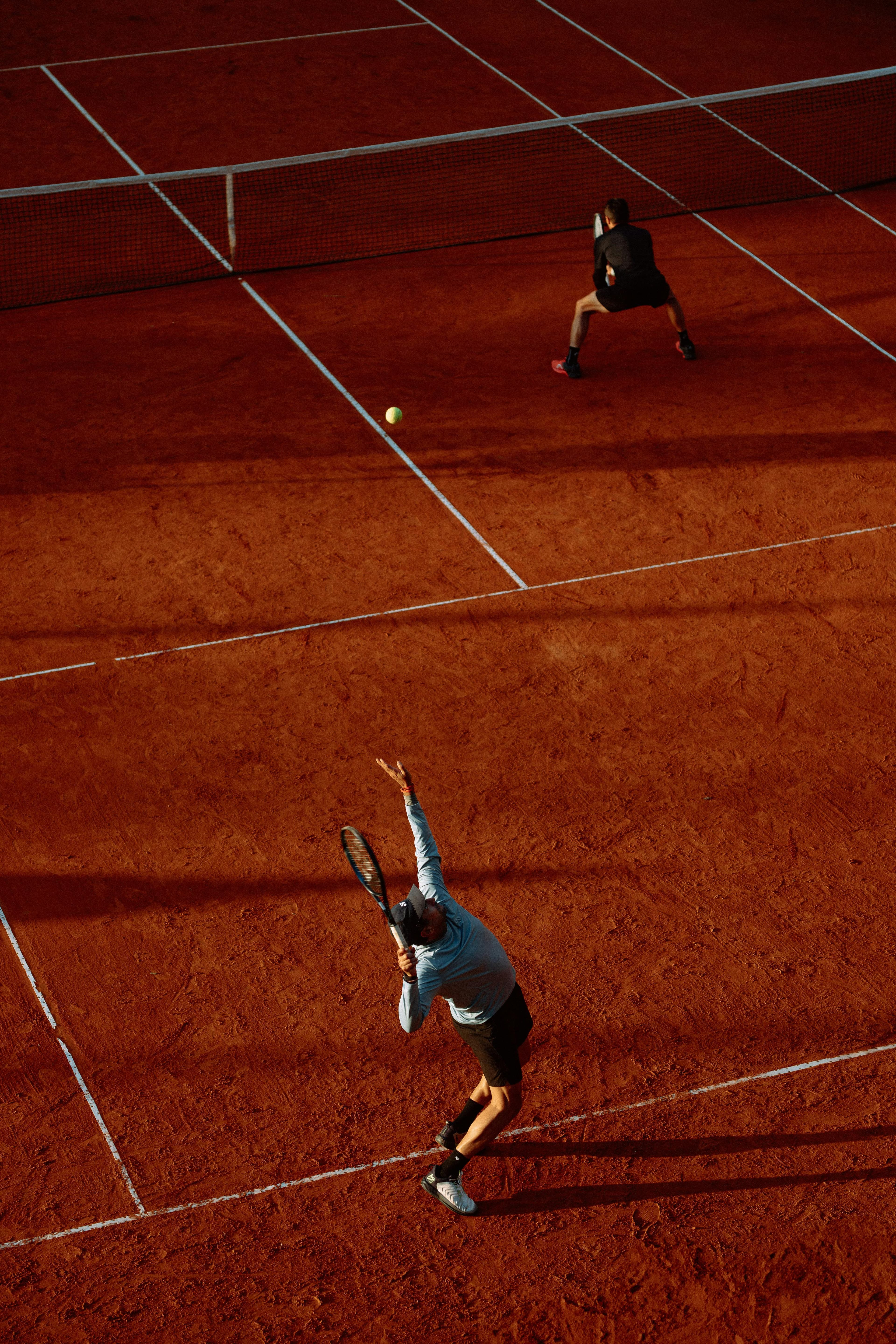 Joueur de tennis en position de service sur terre battue avant un match de compétition