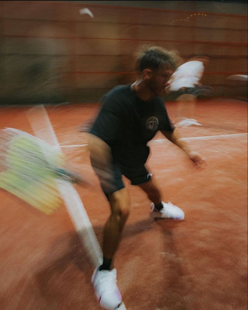 Joueur de tennis concentré avant un service, regard focalisé sur la balle