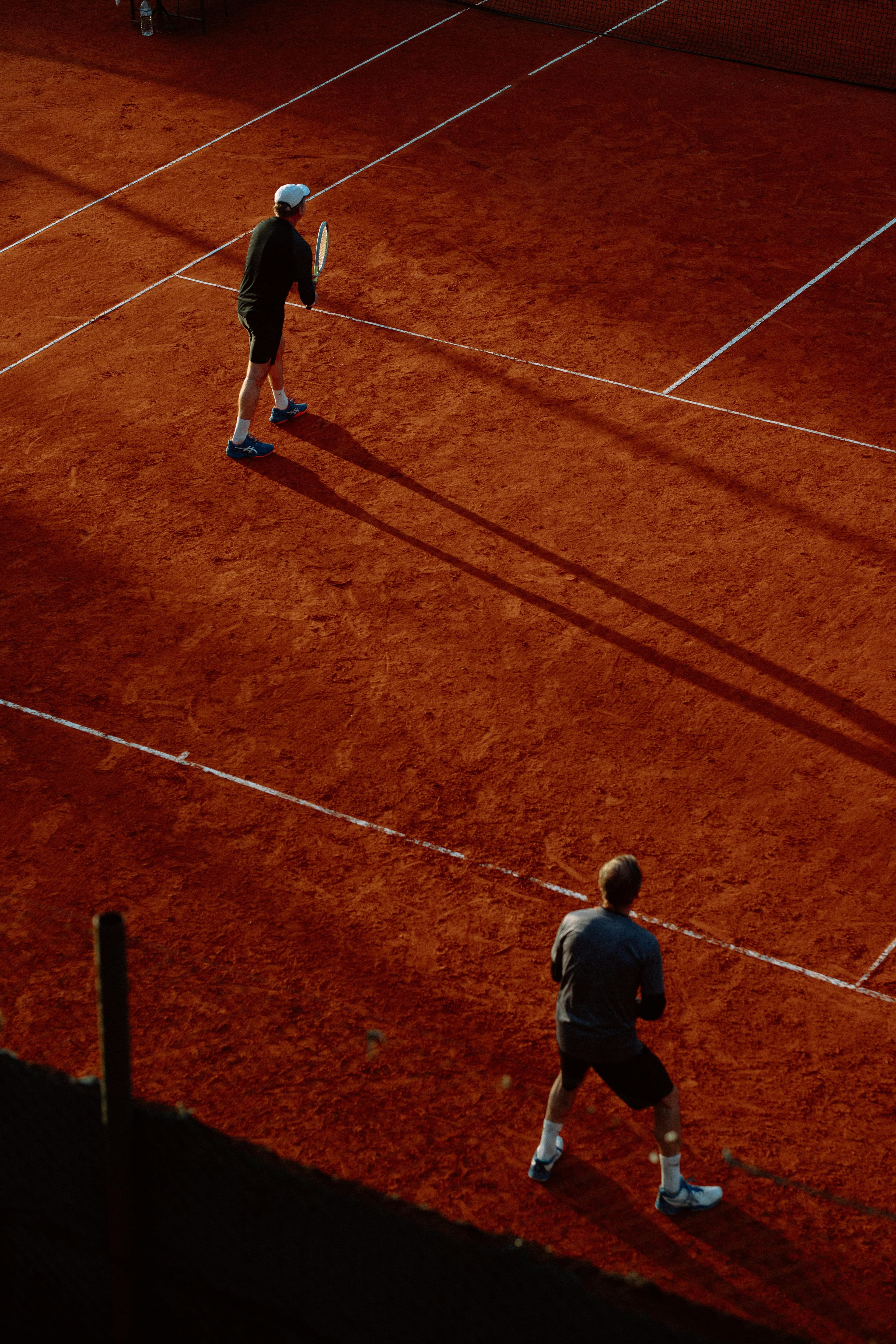Joueur de tennis en action sur court intérieur, frappe de revers en salle